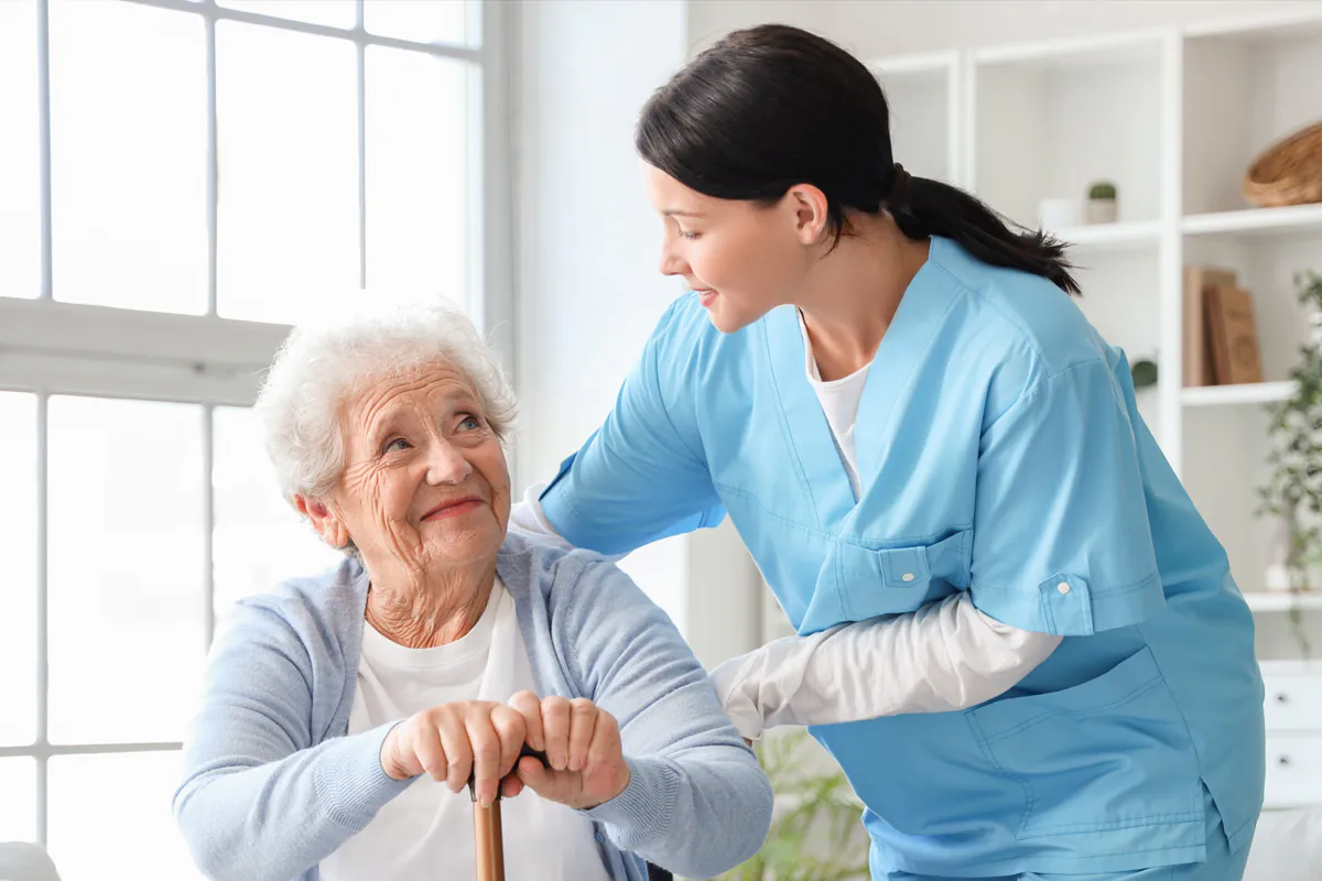 nurse standing with smiling resident