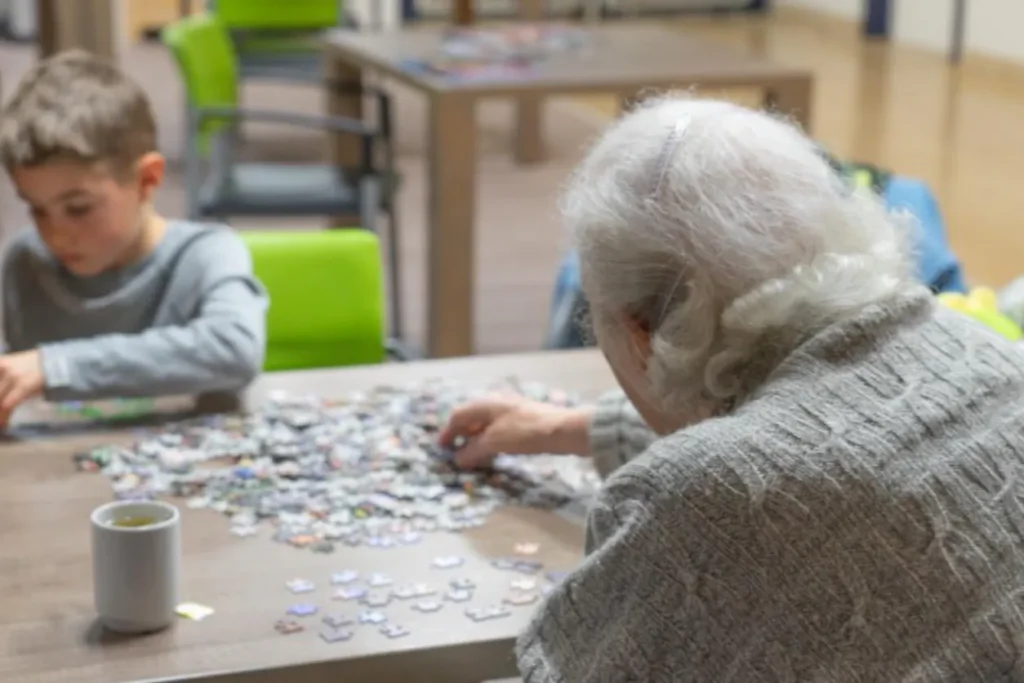 A senior woman and a young child put a jigsaw puzzle together.