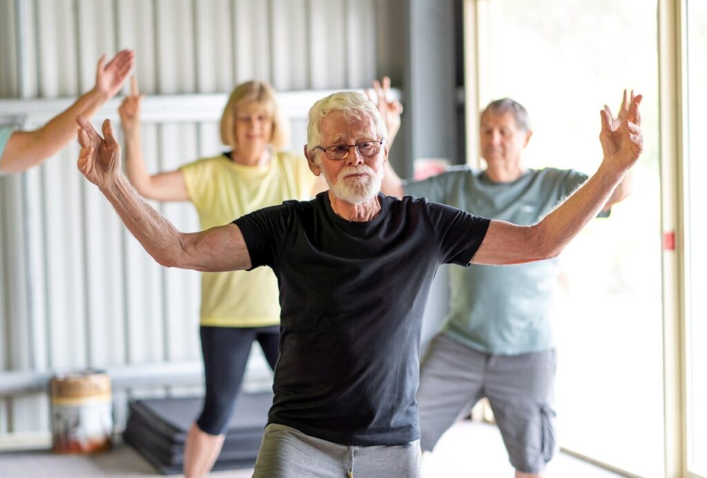 A group of seniors practice tai chi together.