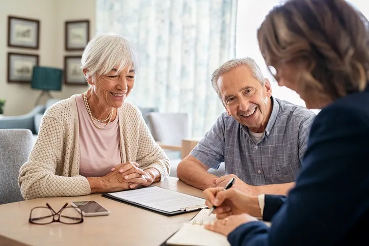 A senior man and woman meeting a medical adviser for health insurance at home.