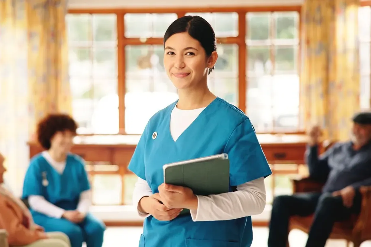 Smiling nurse using tech for digital support in elderly care.