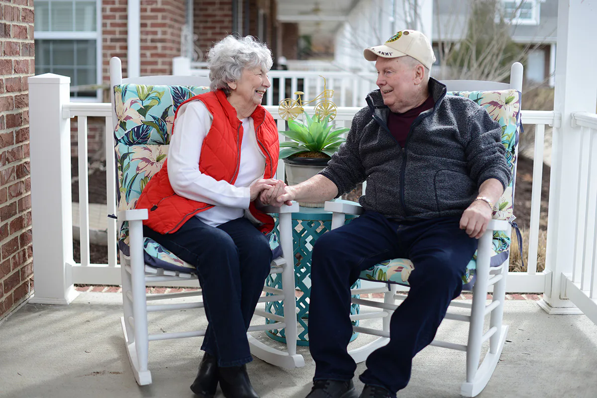 Couple sitting on porch holding hands